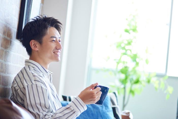 リビングでくつろぐ若い日本人の男性